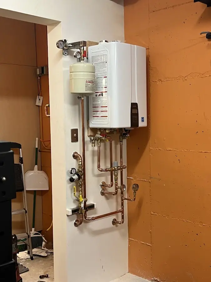 Plumbing technician inspecting water heater connections in Beekman